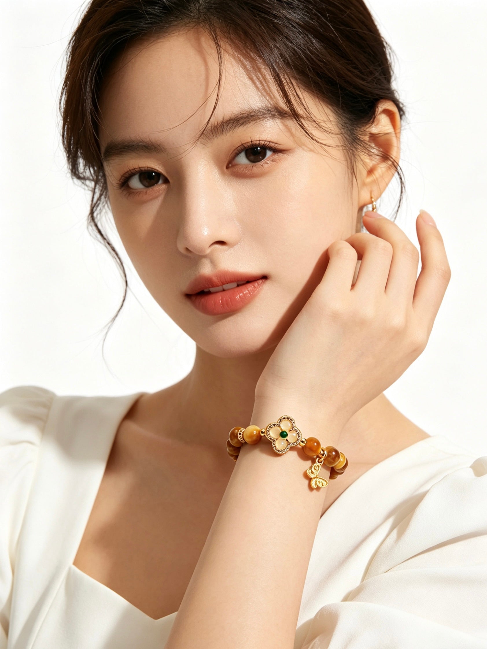 Close-up of female hand gently displaying golden tiger's eye five elements bracelet, plain white outfit, no other jewelry, minimalist white background2