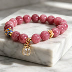Close-up of cloisonne enamel gold bead on pink tourmaline bracelet, traditional craft detail