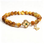 Close-up of natural golden tiger's eye beads with silky cat-eye luster, earth element women bracelet detail shot, clean white background