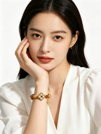 Extreme close-up of female wrist with Earthly Nurture tiger's eye bracelet, lady wearing simple white top, no extra accessories, clean white backdrop