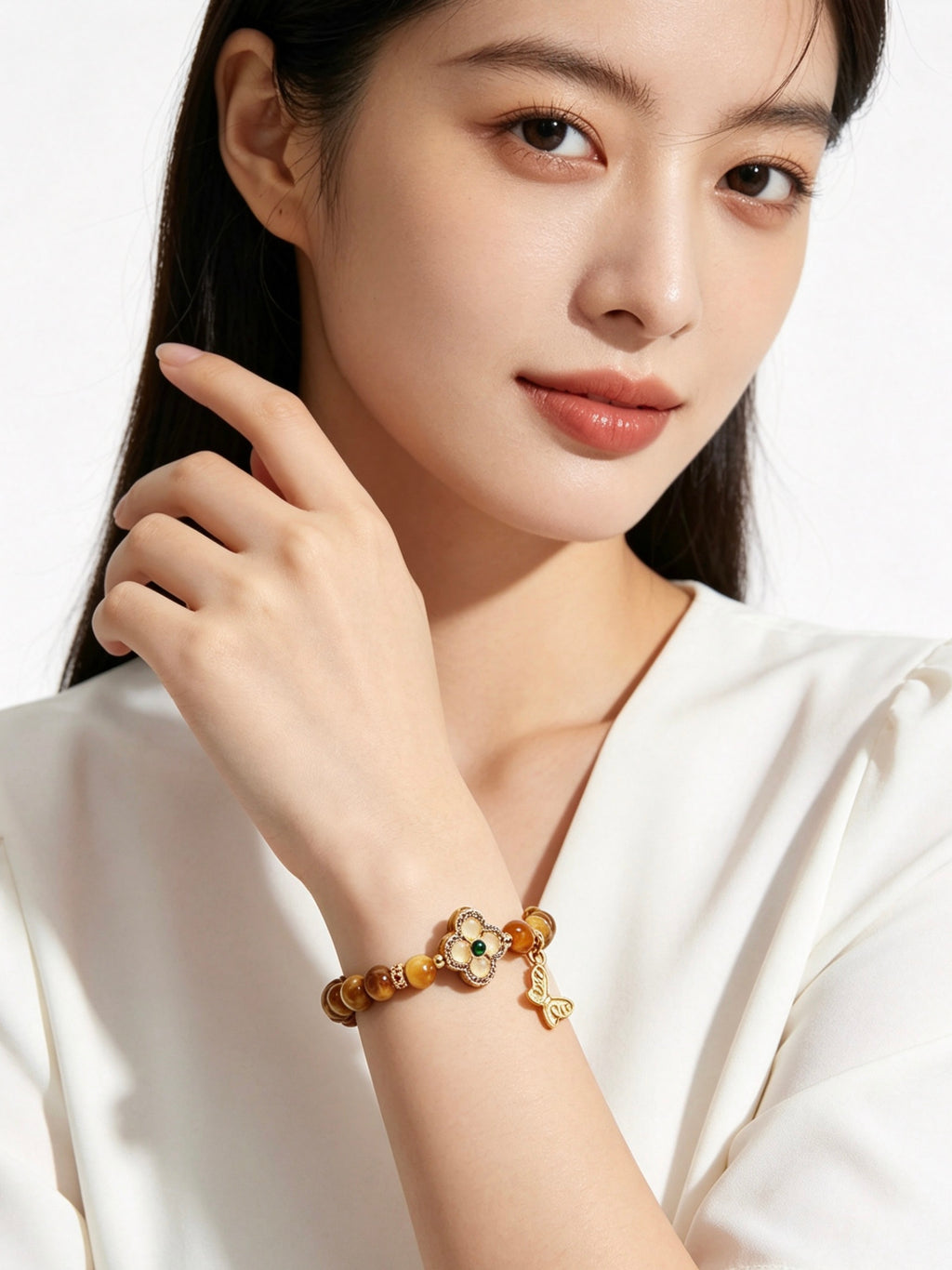 Close-up of female hand gently displaying golden tiger's eye five elements bracelet, plain white outfit, no other jewelry, minimalist white background