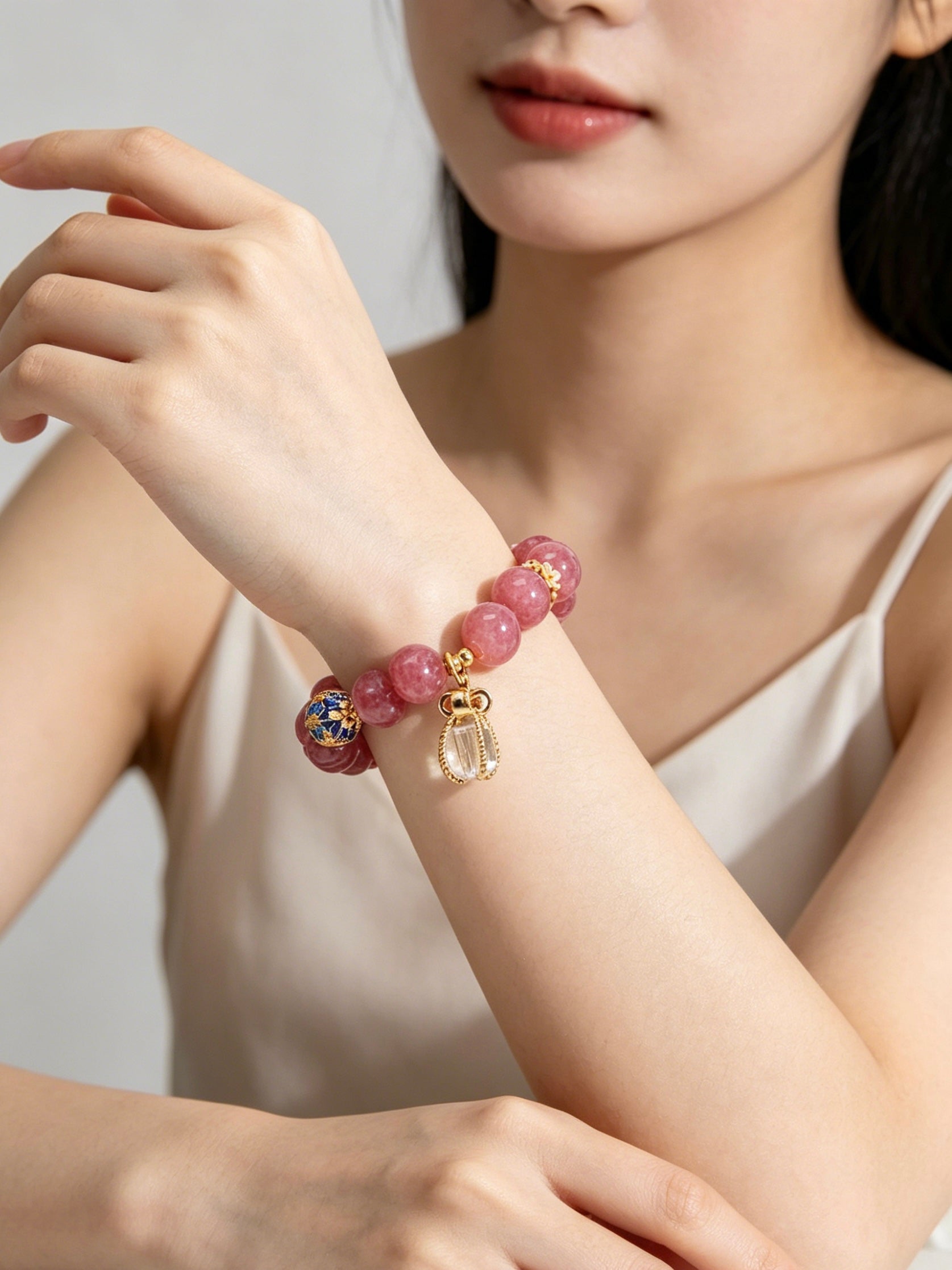 Partial shot of lady’s forearm with fire element five elements pink tourmaline bracelet, elegant niche chinese style jewelry