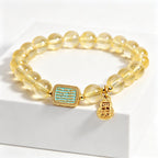 Macro close-up of vintage gold rectangular five-text ornament on Metal Balance citrine bracelet, glossy turquoise enamel texture detail, clean white studio backdrop