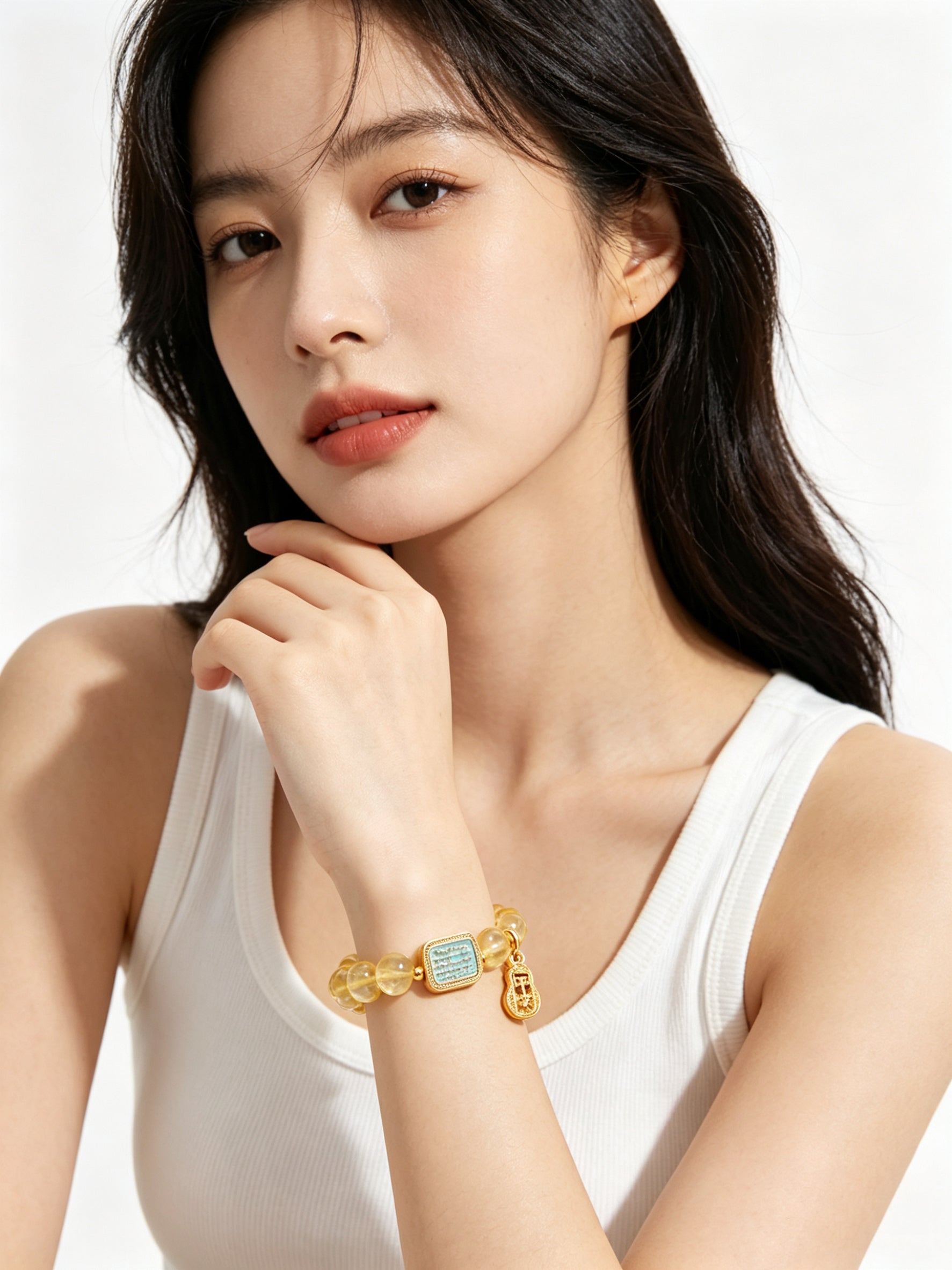 Close-up of hollow gold safe gourd "peace" pendant on metal element citrine bracelet, delicate vintage carving details against white background