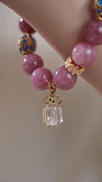 Vertical slow motion video showcasing oriental fire series pink tourmaline bracelet on female wrist, delicate handmade stone jewelry daily wearing effect, no face visible
