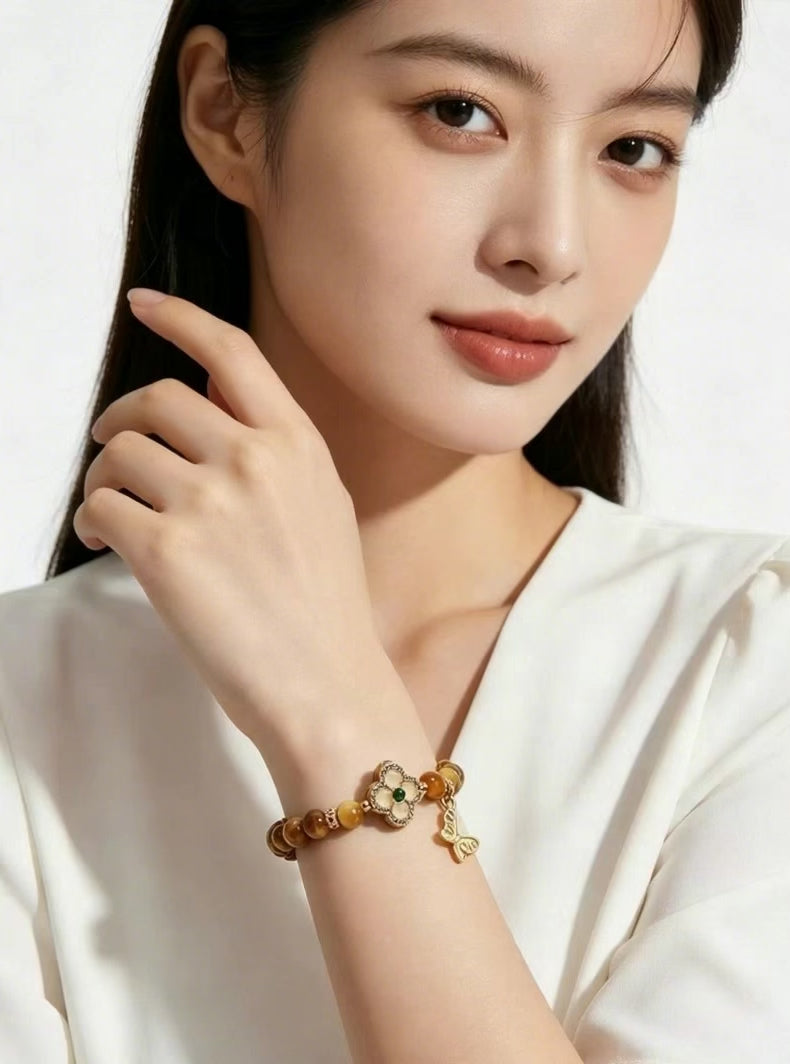 Vertical e-commerce short video of Earth Element tiger's eye bracelet as friendship gift, female model in white top, minimalist white backdrop jewelry display