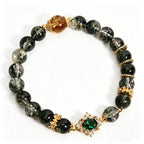 Wood Element Wooden Growth green phantom crystal bracelet, oriental five elements aesthetic women jewelry with emerald inlaid ornament and golden rutilated bead, plain solid white background e-commerce main product shot